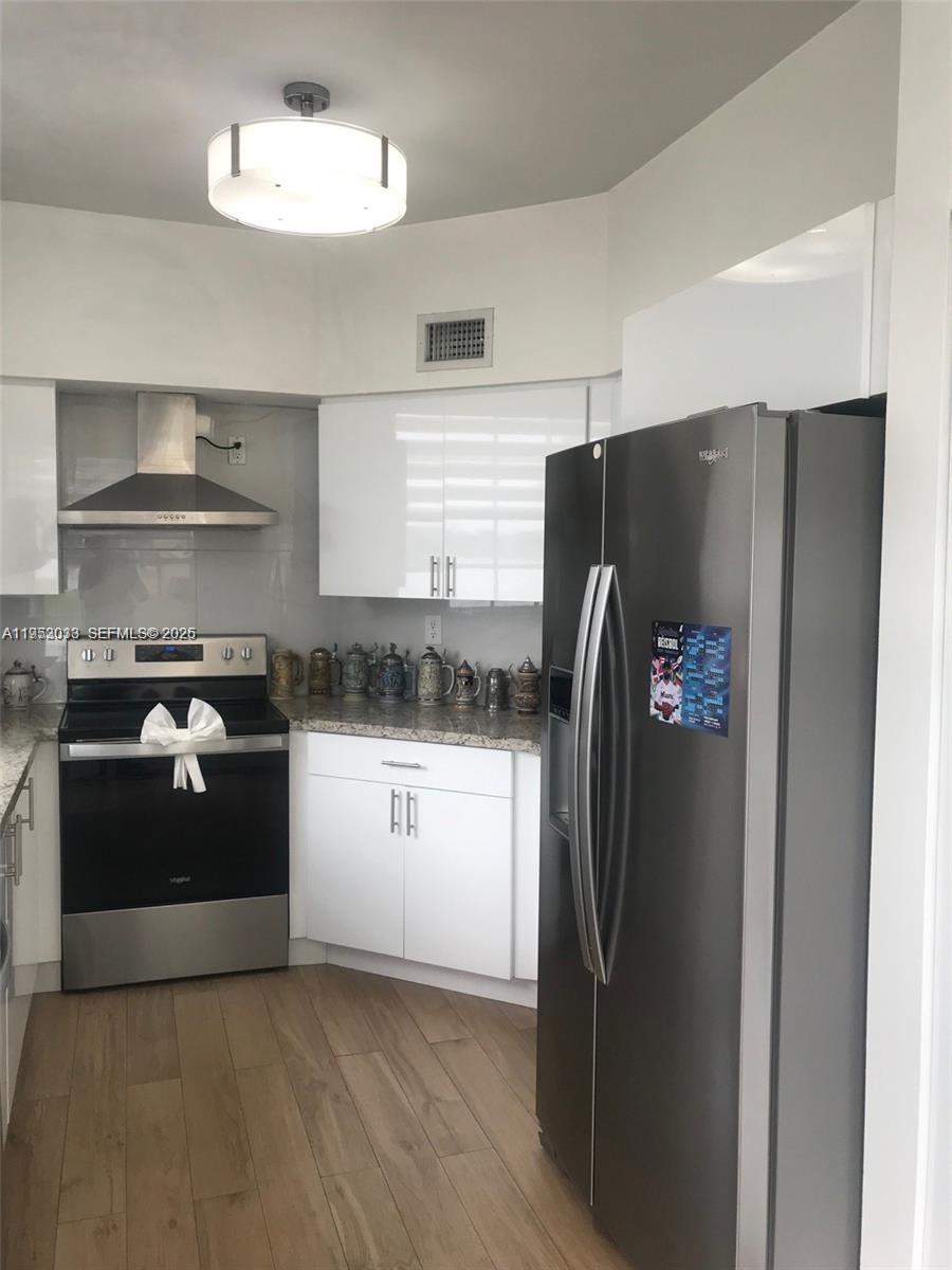 14621 Balgowan Road, Unit 1023 Miami Lakes, FL 33016 - Photo 9 of 21 a kitchen with stainless steel appliances a refrigerator and a stove