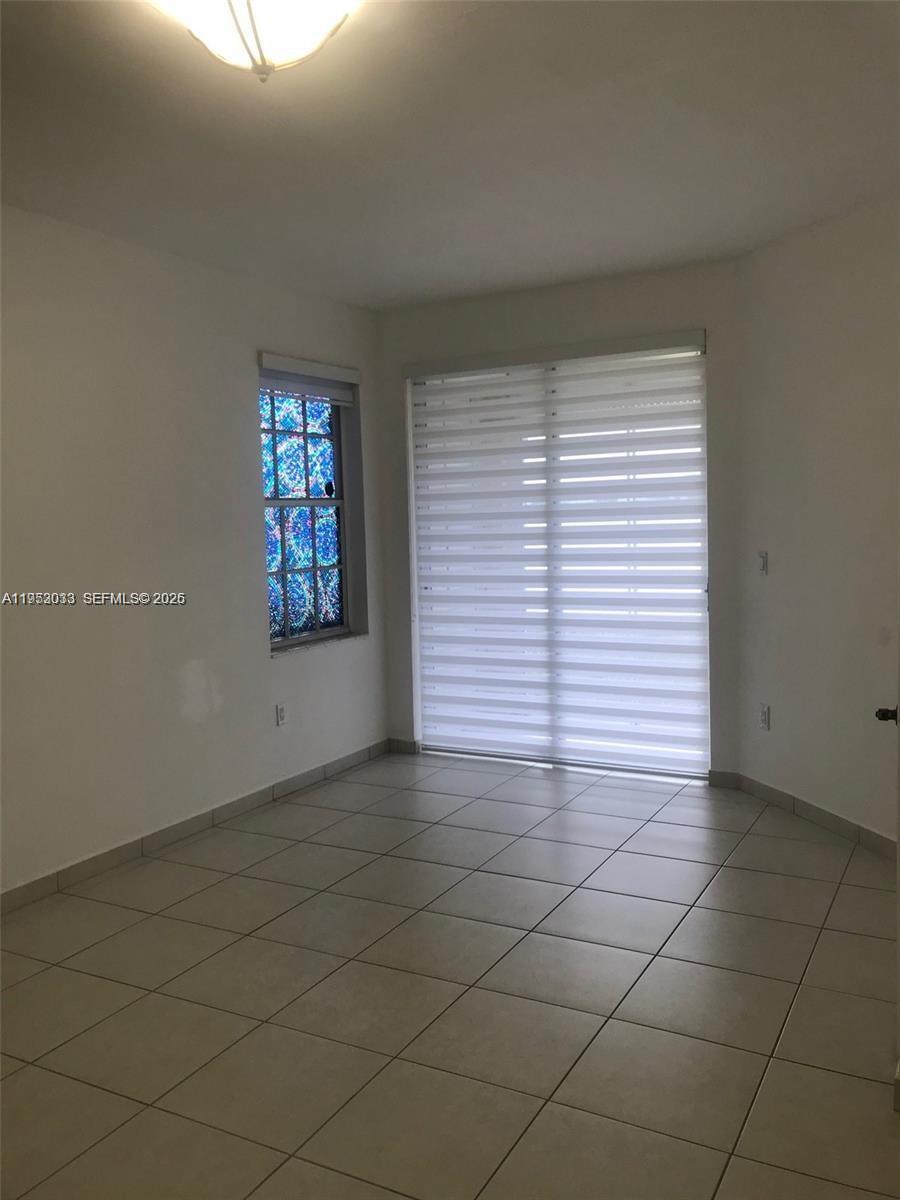 14621 Balgowan Road, Unit 1023 Miami Lakes, FL 33016 - Photo 10 of 21 an empty room with a white cabinet and a window