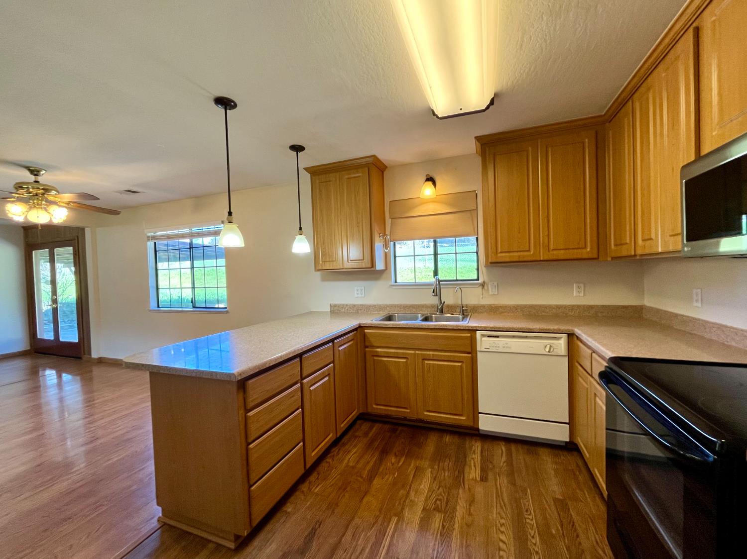 10747 Mt Vernon Road Auburn, CA 95603 - Photo 13 of 33 a kitchen with kitchen island granite countertop a sink cabinets and wooden floor