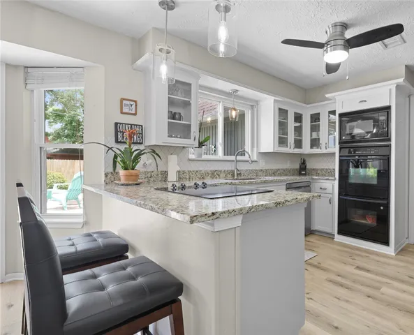a kitchen with kitchen island a large window and cabinets