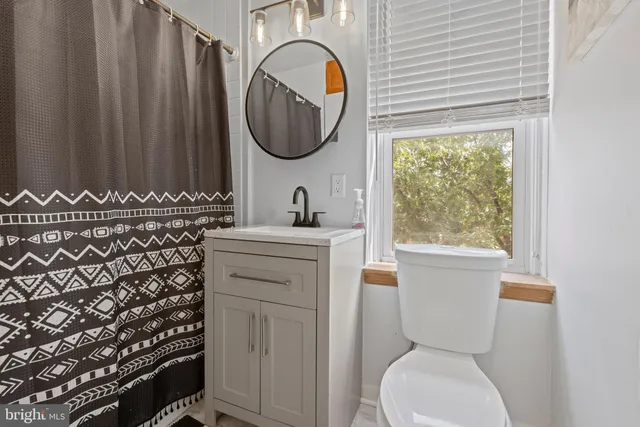 a bathroom with a toilet a sink and a window