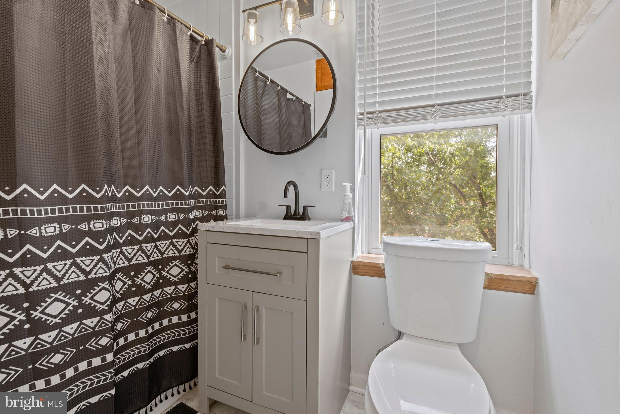 32 West Montgomery Street, Unit C Baltimore, MD 21230 - Photo 14 of 23 a bathroom with a toilet a sink and a window