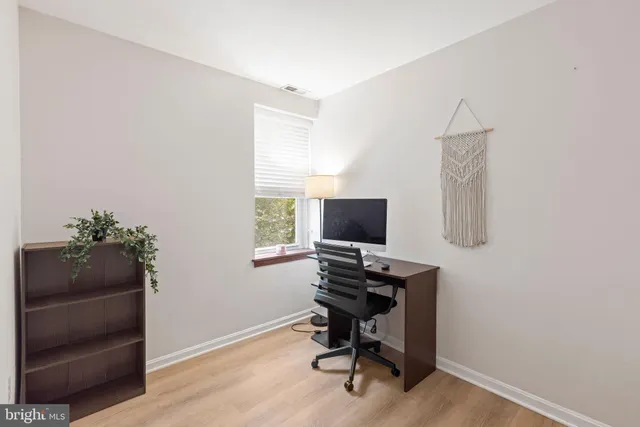 a view of a workspace with furniture and a window