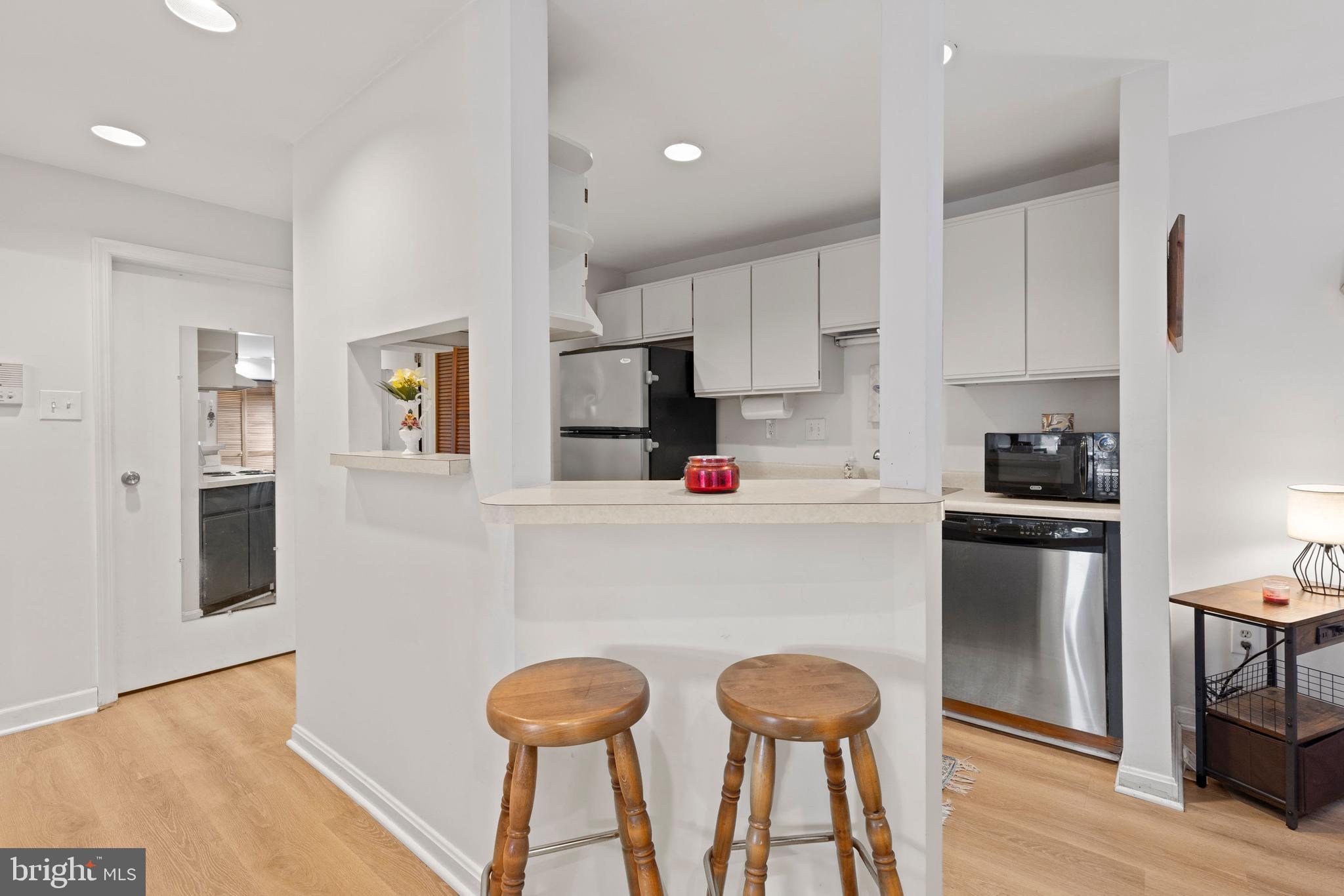 32 West Montgomery Street, Unit C Baltimore, MD 21230 - Photo 7 of 23 a kitchen with stainless steel appliances kitchen island granite countertop a refrigerator a stove and white cabinets with wooden floor