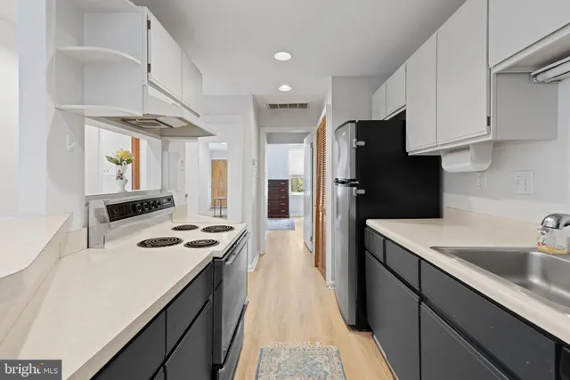 a kitchen with a sink a refrigerator and cabinets