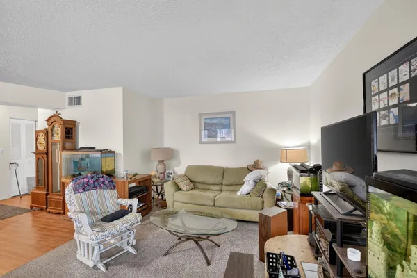 a living room with furniture a flat screen tv and a window