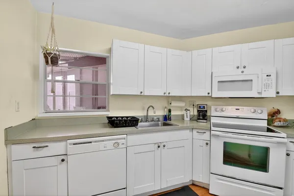 a kitchen with cabinets appliances a sink and a counter top space