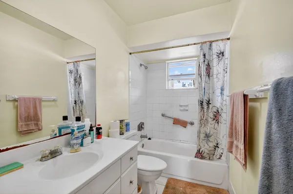 a bathroom with a sink a toilet and shower curtain