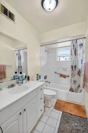 a bathroom with a granite countertop sink mirror vanity bathtub and a toilet