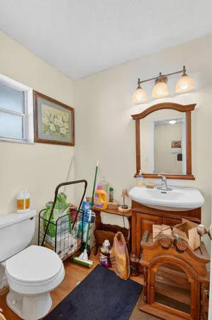 a bathroom with a toilet a sink and mirror