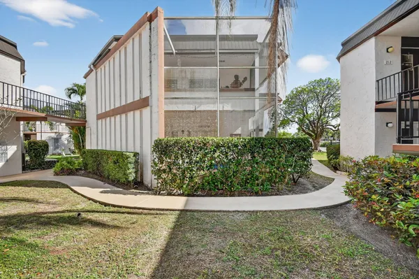 a view of a house with a yard and potted plants
