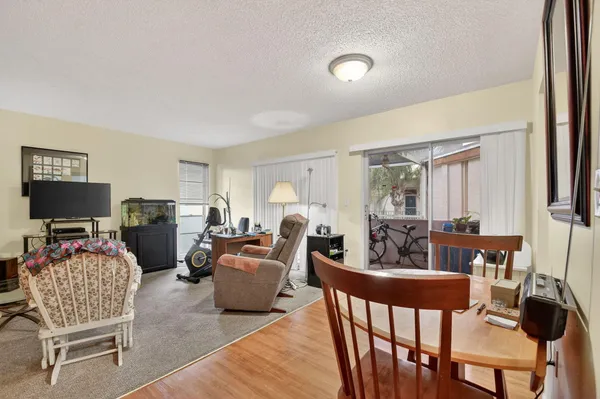 a living room with furniture a flat screen tv and a large window