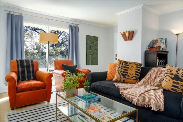 a living room with furniture two window and a flat screen tv