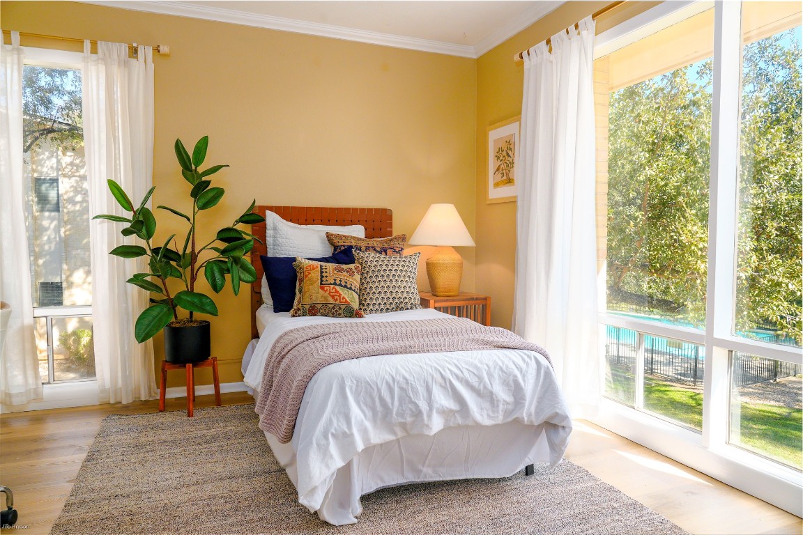5326 Balcones Drive, Unit D Austin, TX 78731 - Photo 11 of 28 a bed sitting in a bedroom next to a window