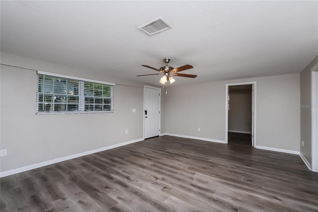 7145 Pinewood Drive New Port Richey, FL 34652 - Photo 2 of 16 a view of empty room with wooden floor and fan