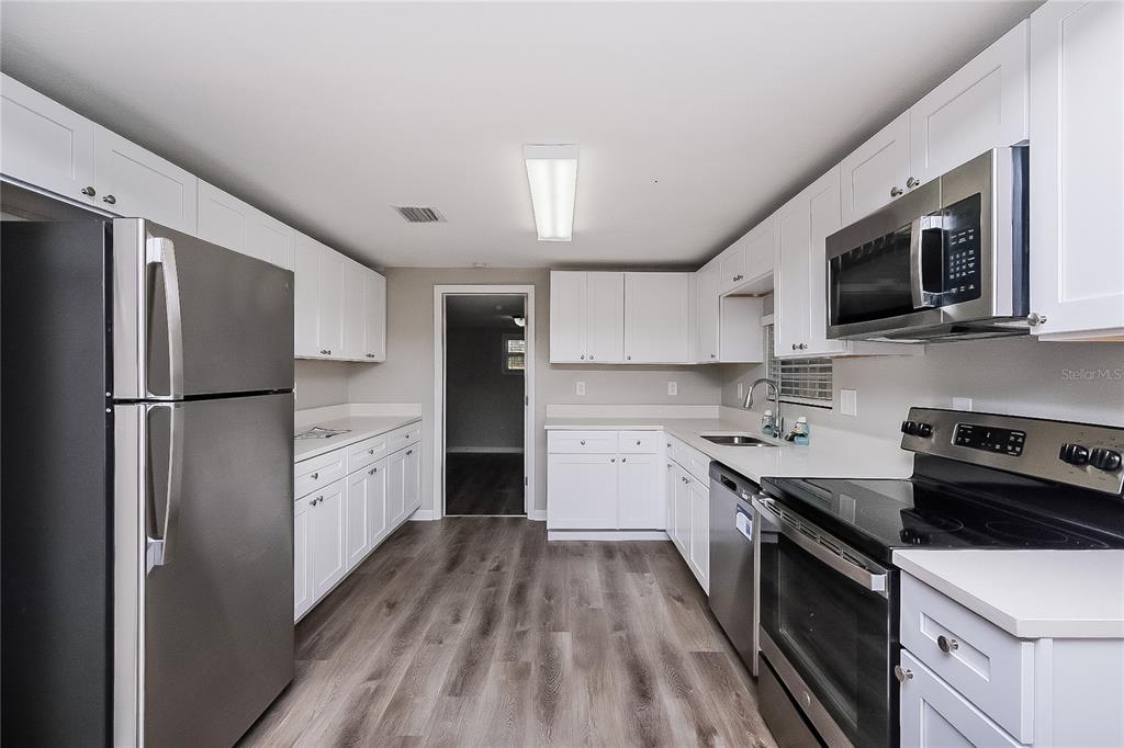 7145 Pinewood Drive New Port Richey, FL 34652 - Photo 5 of 16 a kitchen with stainless steel appliances a refrigerator sink and microwave