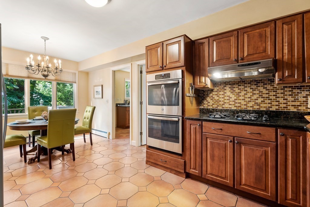 16 Carlton Road Marblehead, MA 01945 - Photo 12 of 42 a kitchen with stainless steel appliances granite countertop a stove top oven a dining table and chairs with wooden floor