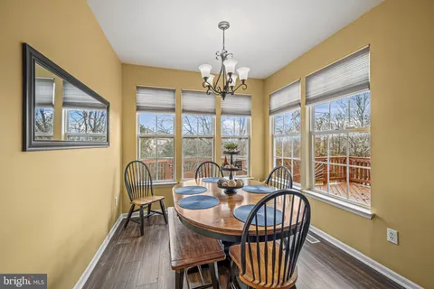 a view of a dining room with furniture a chandelier and wooden floor