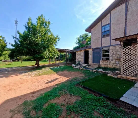 a view of a house with backyard and a tree