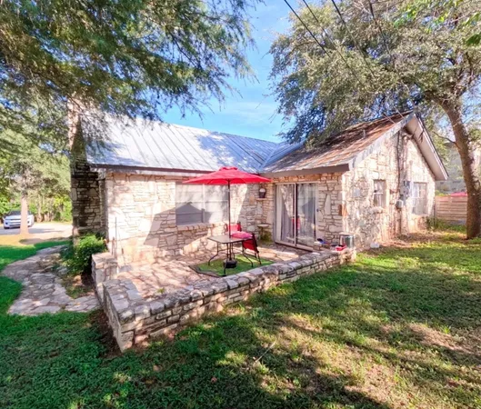 a view of a backyard with table and chairs and a large tree
