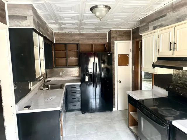 a kitchen with stainless steel appliances kitchen island granite countertop a refrigerator and a stove