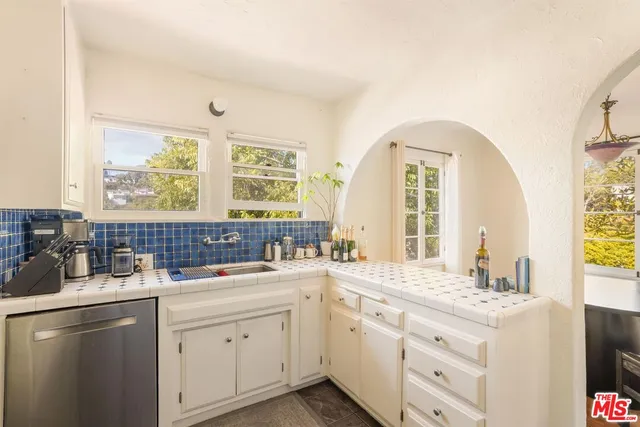 a kitchen with a refrigerator and a stove top oven