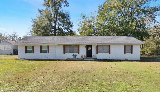 a front view of house with yard and trees around
