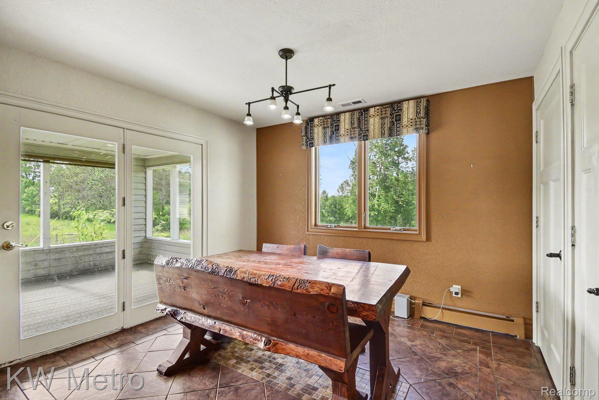 2682 East Haskell Lake Road Harrison, MI 48625 - Photo 17 of 61 Dining area with tile flooring and a multi-light chandelier