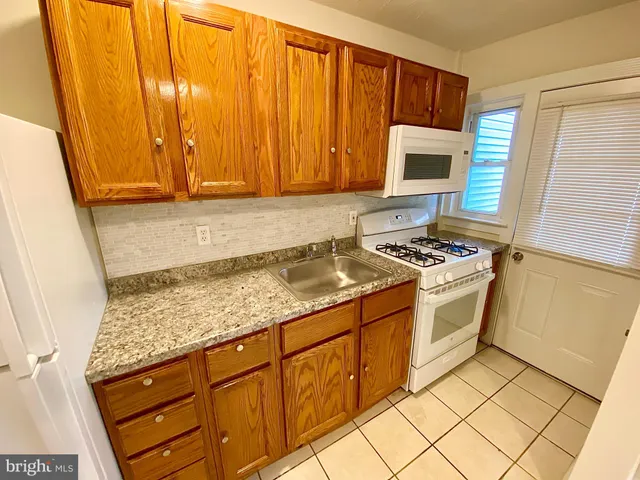 a kitchen with granite countertop cabinets and black appliances