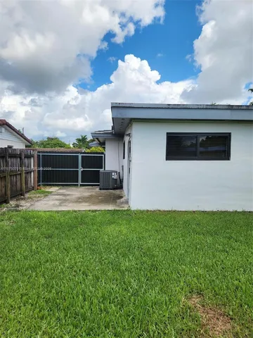 a view of a house with a yard and sitting area