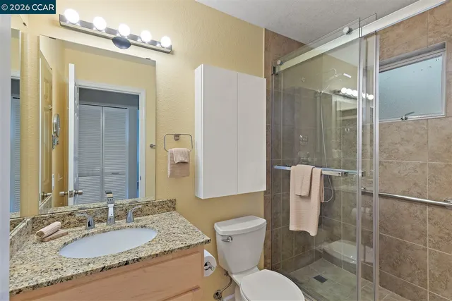 a bathroom with a granite countertop sink toilet and shower