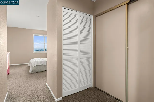 a bedroom with a white bed and a window