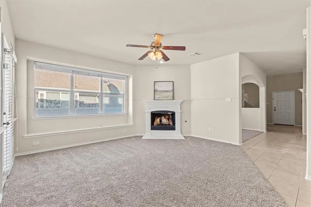 a view of an empty room with a fireplace and a window