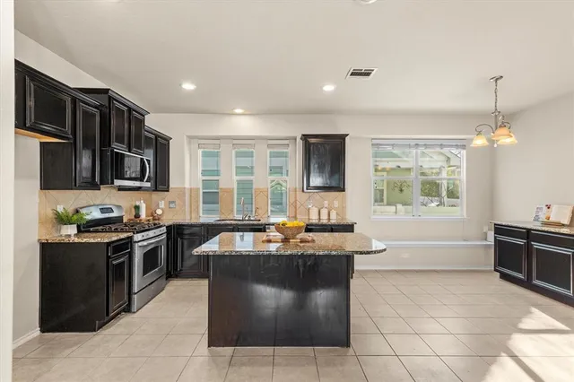 a kitchen with stainless steel appliances granite countertop a sink and a stove
