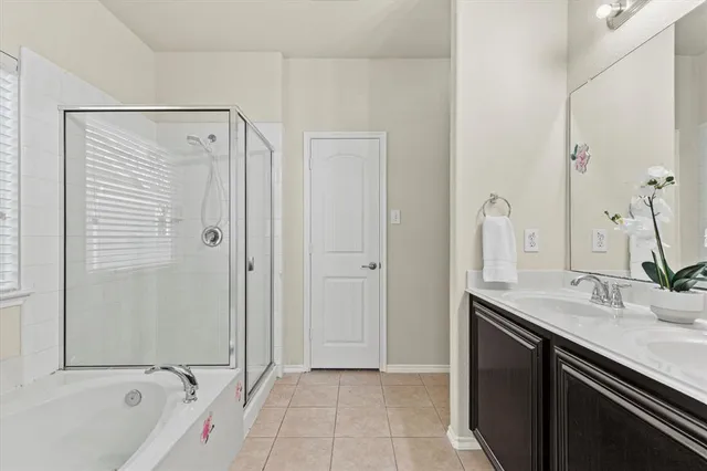 a bathroom with a double vanity sink a mirror and a bathtub