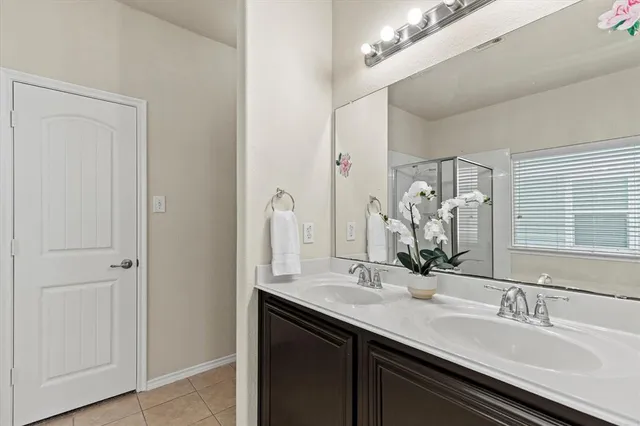 a bathroom with a double vanity sink a vanity and a mirror