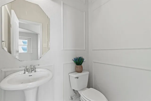 a bathroom with a toilet sink and mirror