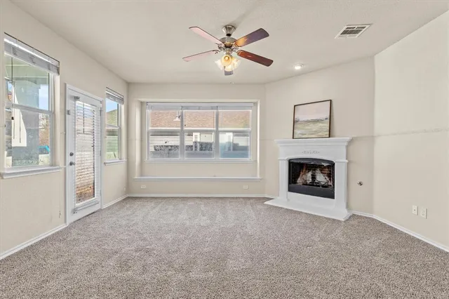 a view of an empty room with a fireplace and a window
