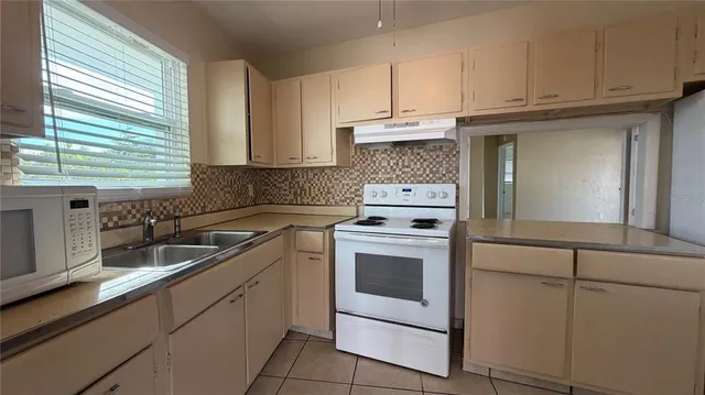 a kitchen with granite countertop white cabinets and white appliances