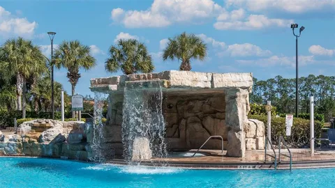 a front view of a house with garden and trees