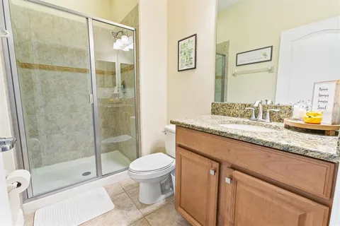 a bathroom with a granite countertop sink toilet and shower