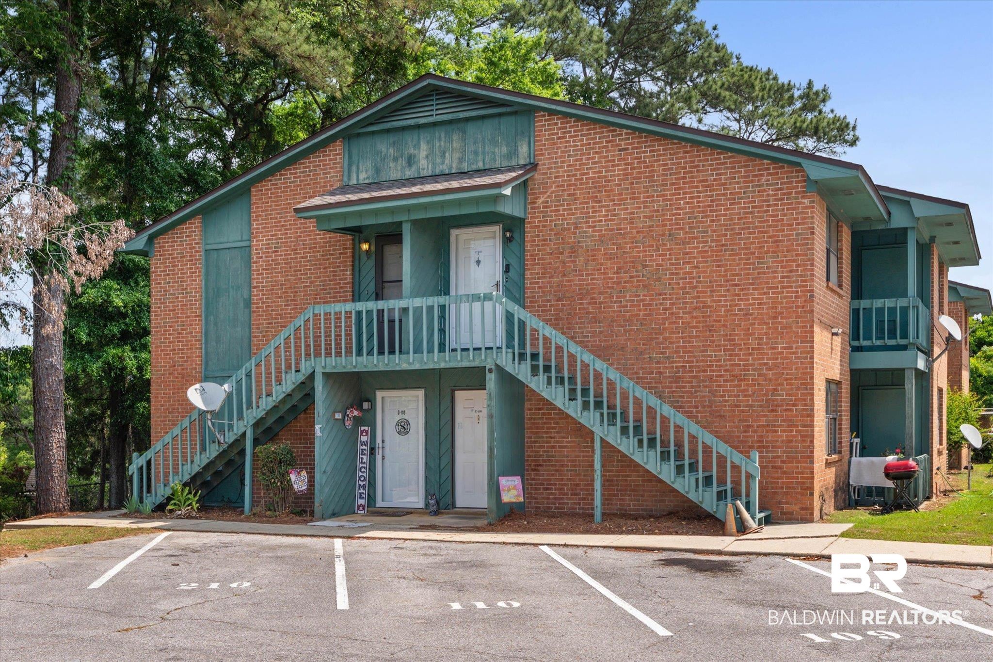500 Grant Street, Unit C210 Daphne, AL 36526 - Photo 1 of 26 Two-story brick exterior building featuring teal trim and exposed wooden staircases