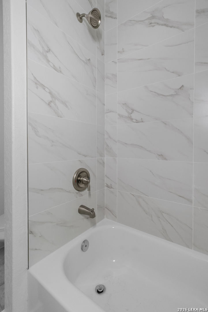 804 Peach Street Jourdanton, TX 78026 - Photo 11 of 16 a bathroom with a tub