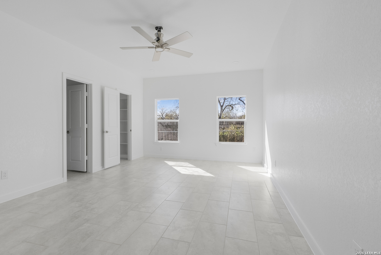 804 Peach Street Jourdanton, TX 78026 - Photo 14 of 16 an empty room with windows and fan