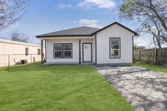 a view of a house with a yard and potted plants