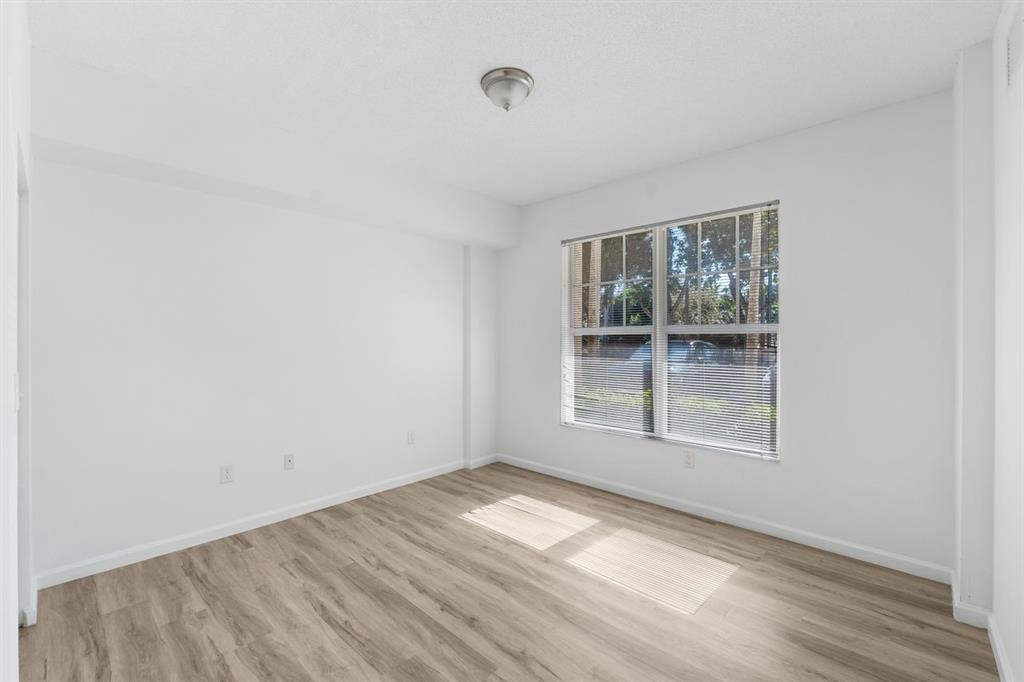 5800 West Sample Road, Unit 102 Coral Springs, FL 33067 - Photo 13 of 23 a view of empty room with wooden floor and fan