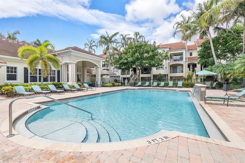 5800 West Sample Road, Unit 102 Coral Springs, FL 33067 - Photo 19 of 23 a view of a swimming pool with a bench and trees in the background
