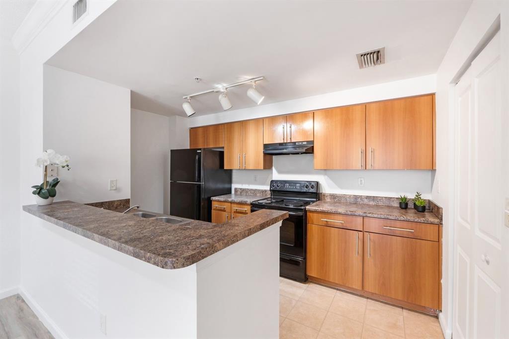 5800 West Sample Road, Unit 102 Coral Springs, FL 33067 - Photo 7 of 23 a kitchen with stainless steel appliances granite countertop a sink stove and refrigerator