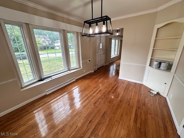 15959 Glynn Road Cleveland, OH 44112 - Photo 8 of 23 Unfurnished dining area featuring ornamental molding, baseboard heating, hardwood / wood-style floors, built in features, and a chandelier