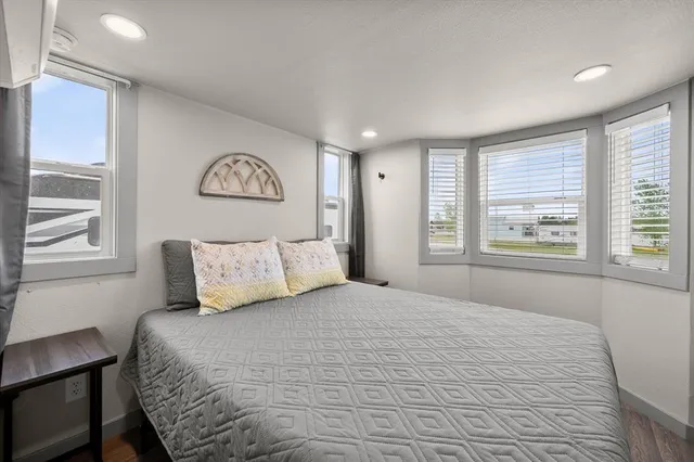 a bedroom with a bed and a refrigerator